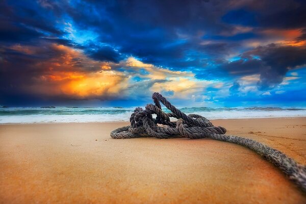 An old abandoned rope on the beach by the sea