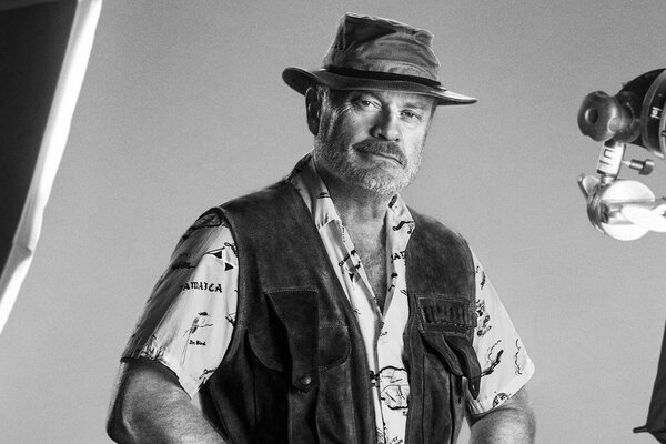 A man with stubble in a hat. Black and white photo