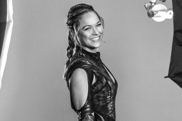 A woman smiles at a photo shoot in a black dress code