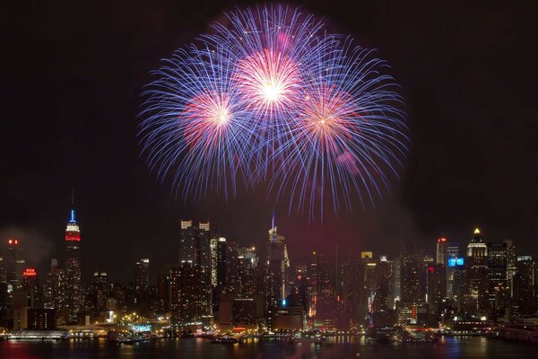 Fuegos artificiales festivos sobre los rascacielos de la ciudad