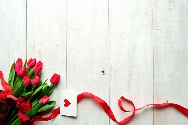 Romantic tulips with a red ribbon and a valentine