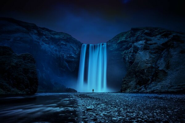 Night Iceland, waterfall and man