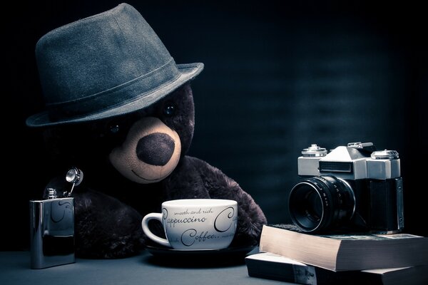 A toy bear in a hat and a cup of coffee