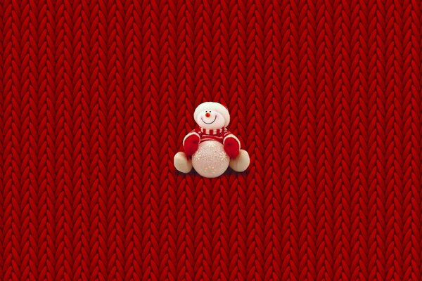 Bonhomme de neige en peluche sur fond tressé rouge