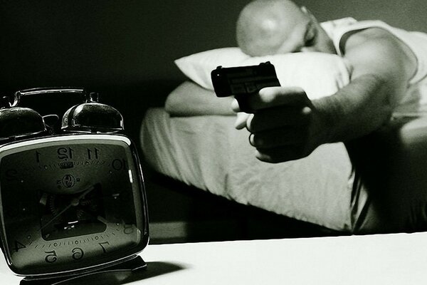 Sleepy bald man threatens alarm clock with a gun