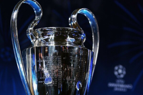 A shiny football cup with a blue tint on a dark background