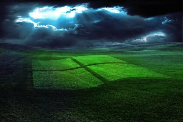 Logotipo de Windows reflejado en un Prado verde, iluminado por los rayos del sol a través de las nubes