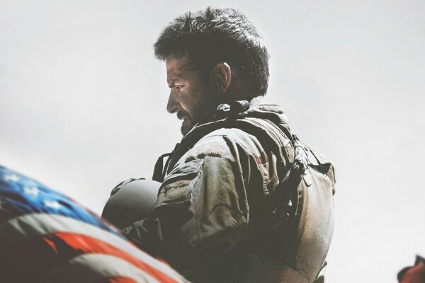 Trauriger Mann in Uniform in der Nähe der amerikanischen Flagge