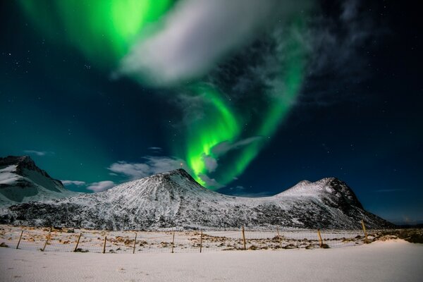 Lueur verte dans le ciel près des montagnes