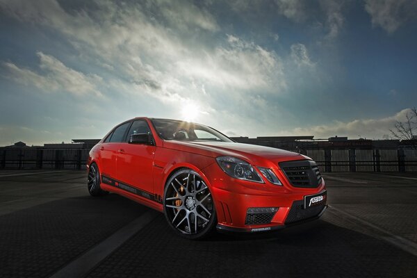 Red Mercedes on the background of the city landscape