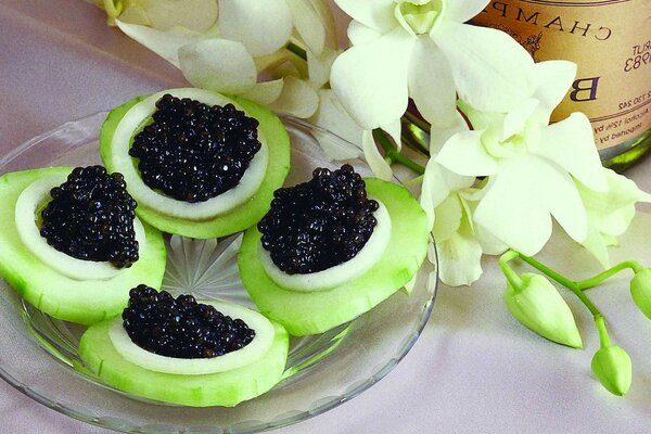 Aperitivo con rodajas de pepino y caviar negro