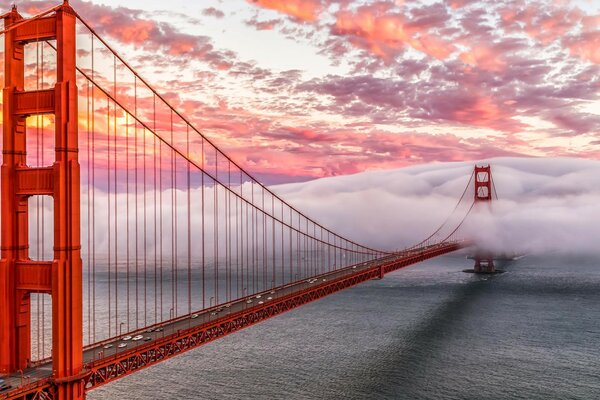 The red bridge over the water surface goes into the fog