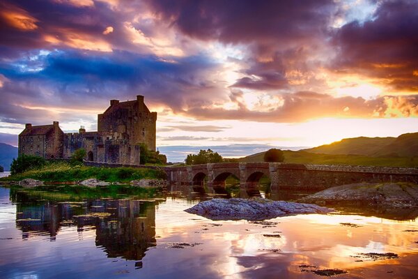 Castle at sunset on the shore of a reservoir