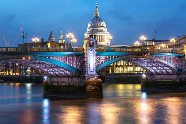 A long bridge on the background of a church and a city