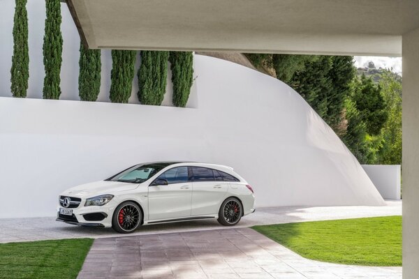 Weißes Mercedes-Benz-Auto im Hof auf weißem Wandhintergrund