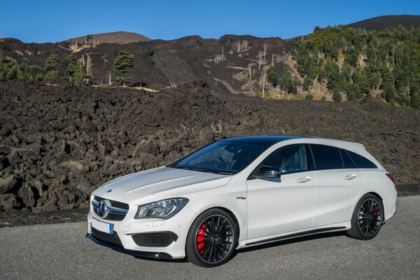 Auto und Natur. Mercedes-Benz vor dem Hintergrund von Felsen und Wäldern