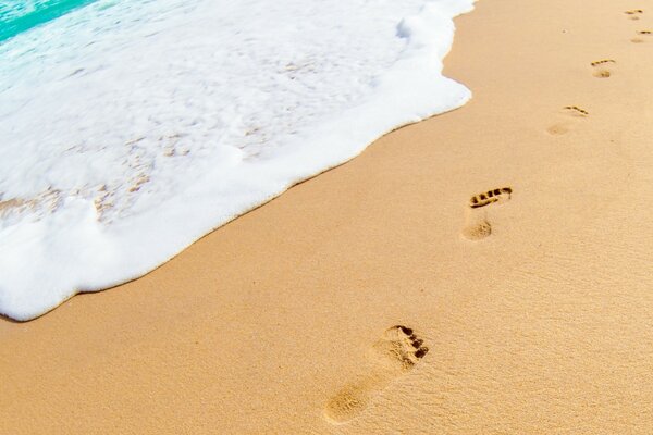 Ein Sommerstrand mit menschlichen Fußabdrücken