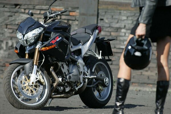 Menina de pé na frente de uma motocicleta esportiva