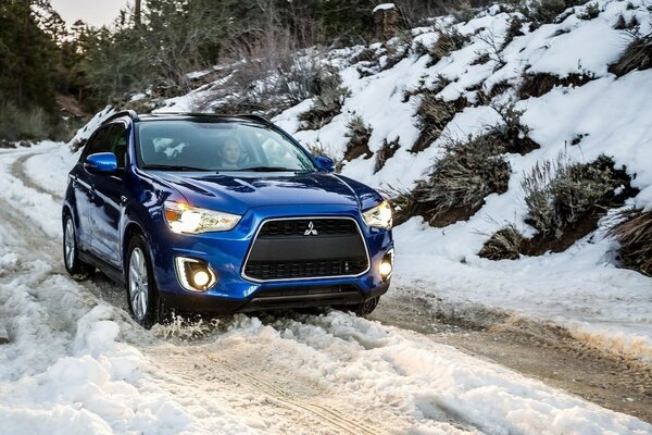 Um carro que atravessa uma estrada coberta de neve