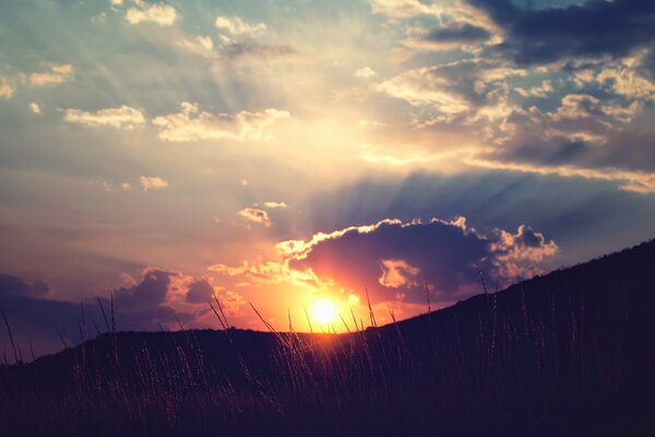 O círculo do sol no fundo das montanhas da noite