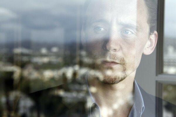 Portrait of a man behind glass in which the city is reflected