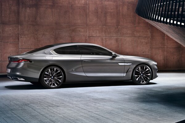 Grey car side view on a brown wall background