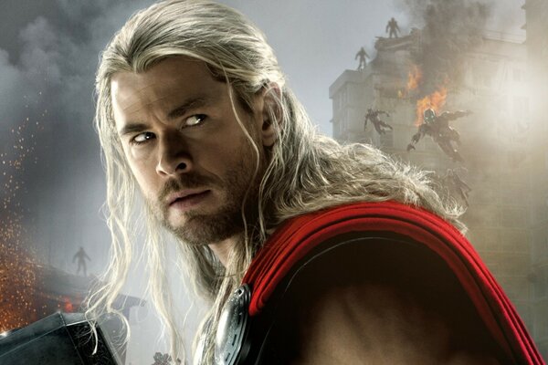 Chris Hemsworth jako Thor. Przystojny napompowany mężczyzna z długimi białymi włosami