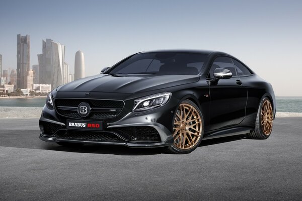 Brutal black Mercedes Benz on the background of tall houses