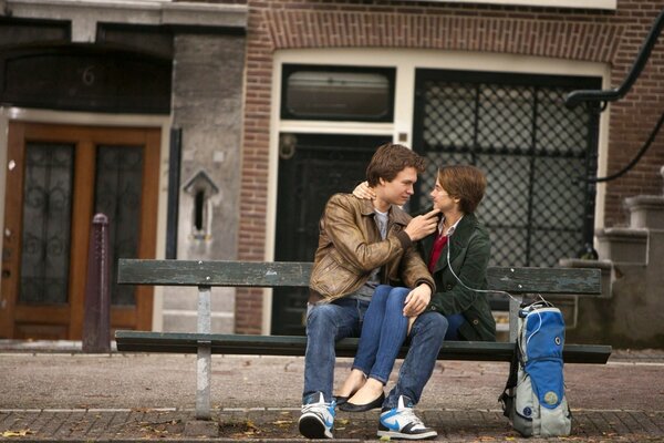 Guy and girl kissing on a bench