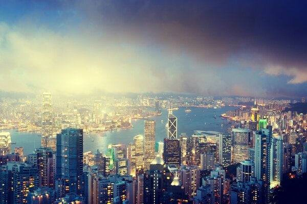 Magnificent view from above of the skyscrapers of the metropolis, the bay, cloudy sky