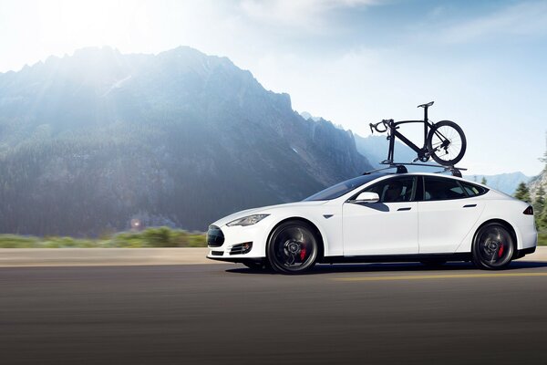 A white car with a bicycle on the roof