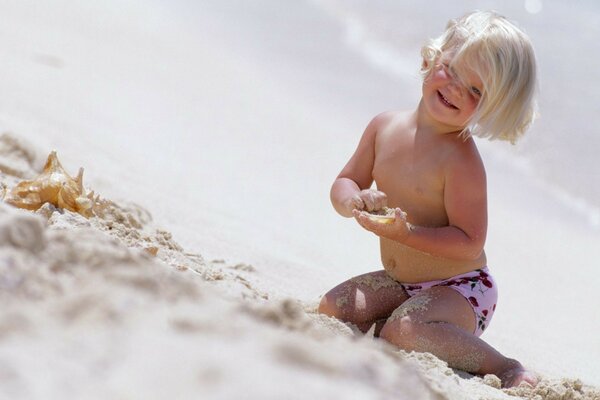 A child playing on the beach in the sand