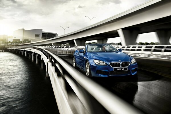 Bmw racing across the bridge of a big city