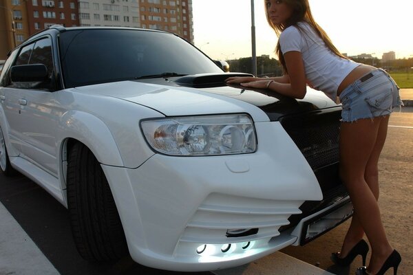 Chica posa en un coche blanco