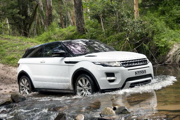 A beautiful car drives through a mountain river