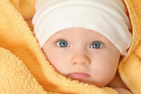 Bébé mignon avec les yeux bleus et la peau délicate