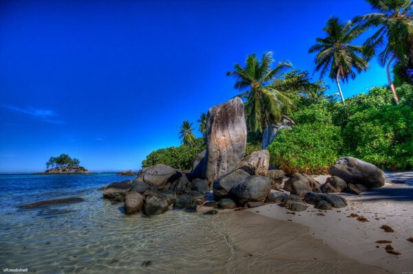 A tropical beach on the seashore. Rocks on the shore