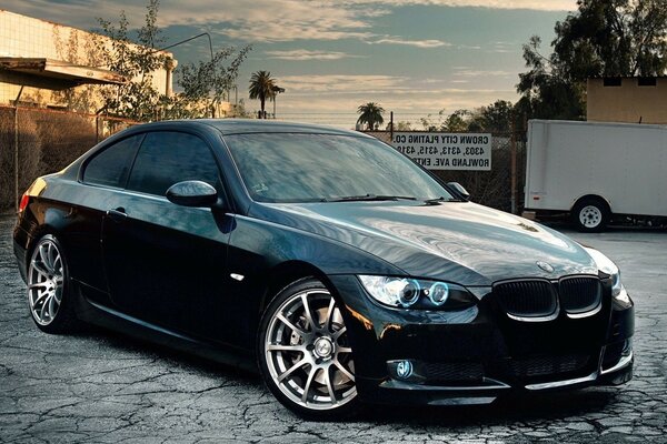 A black car on a gray sidewalk