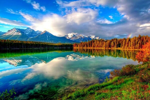 Las nubes y las montañas se reflejan en el lago