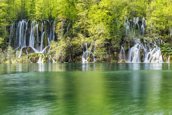 Вода стекает в зелёное озеро