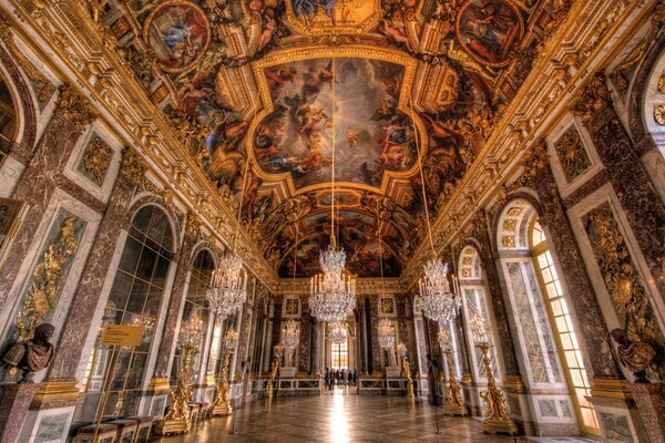 Painted ceilings and walls with large lamps and a floor made of colored stones inside the church