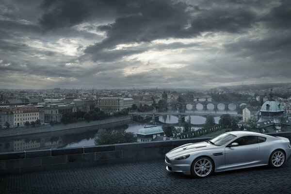 Aston Martin на фоне города с тучами