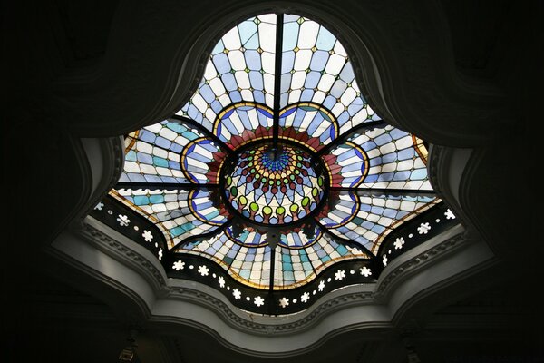 En el interior, el techo del edificio está decorado con una cúpula compleja con adornos de vidrio de color