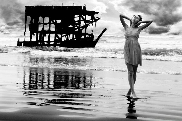 Chica posando en un vestido en la playa junto al océano