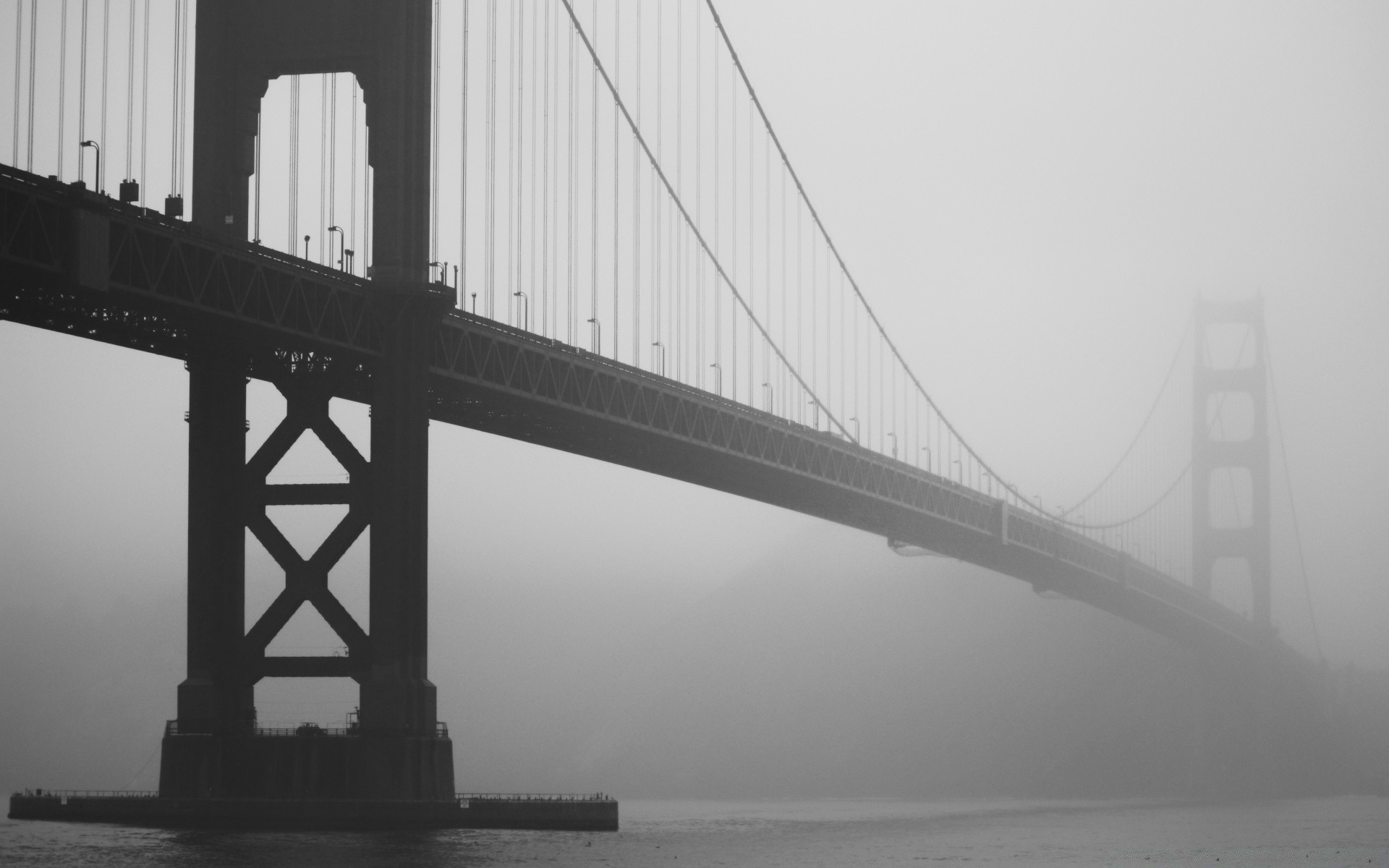 black and white bridge suspension bridge water river architecture transportation system city monochrome connection suspension travel sky fog building construction road urban sunset light