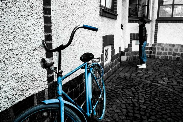 Bicicleta azul fica em fundo preto e branco