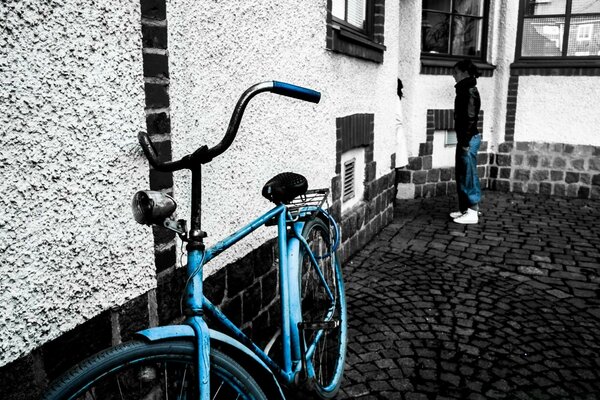 Блакитний велосипед стоїть на чорно-білому тлі