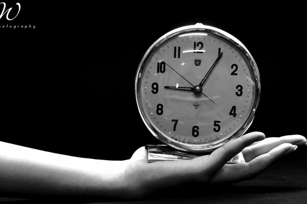 A black-and-white clock, time rushes its flight into the distance and burns bridges between the past and the present