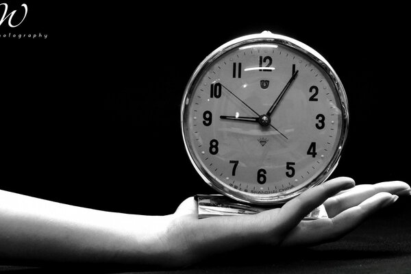 El reloj blanco y negro, el tiempo corre en la distancia y quema los puentes entre el pasado y el presente