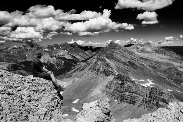 Black and white photo of a traveler on the edge of a mountain